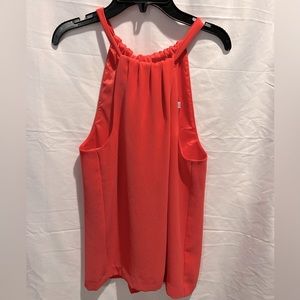 Trina Turk halter in orange-red with tie at the back of neck.
